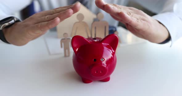 Insurance Agent Protects t Piggy Bank and Family with House with Hands