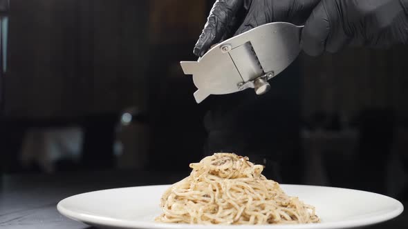 Chef Grates Black Truffle on Pasta in Italian Restaurant. Slow Motion. Concept of Gourmet Cuisine