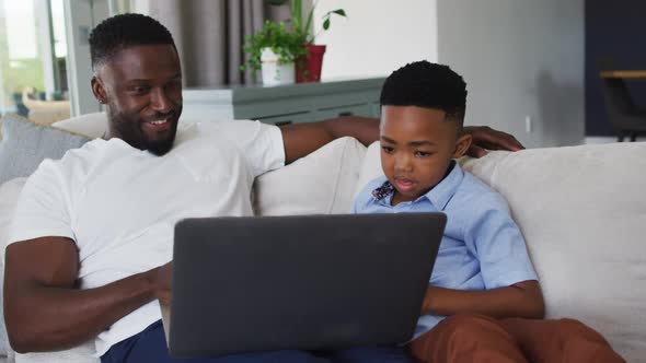 African american father and son using a laptop together