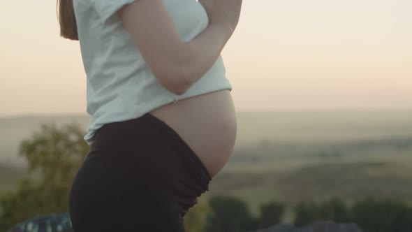 Confident White Pregnant Woman in Sports Clothes Does Yoga Outdoor Side View Closeup