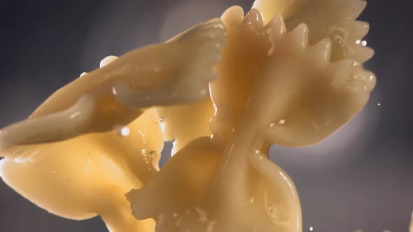 Pasta Farfalle is Flying Up on a Kitchen Bokeh Background