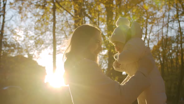 Happy mom is spinning with toddler hugging him