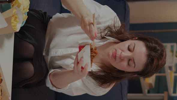 Vertical Video Person Eating Asian Noodles with Chopsticks on Couch