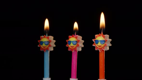 Birthday Festive Candles in Form of Sun in Sunglasses Turning Spinning Isolated on Black Background