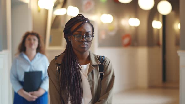 Depressed Afro-american Female Student Walking in College Corridor