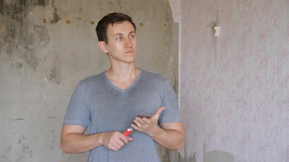 Man with Pallet in Hand Standing in Room of Apartment