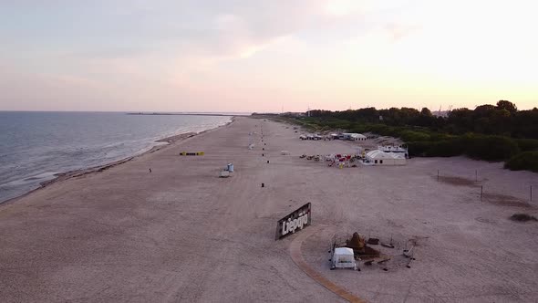 Beautiful aerial view of a long sandy empty Baltic sea beach at Liepaja after the sunrise, calm wate