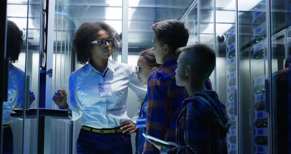 Female Technician Showing Around Children in a Server Park