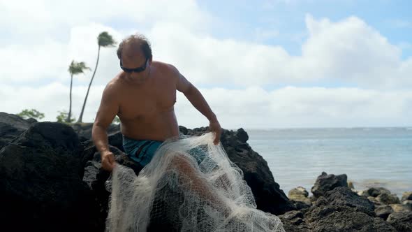 Fisherman holding fishing net in the beach 