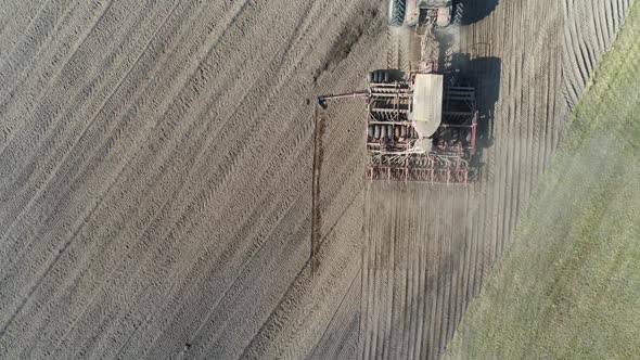 Countryside and Agriculture Farm Tractors Plow the Earth in Field Dust in the Field View From Height