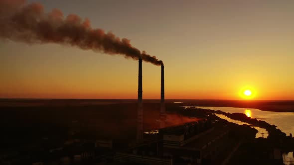 Air pollution. Dark smoke goes from industrial pipes at sunset. 