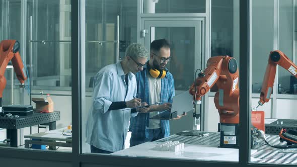 Laboratory with Two Researchers Testing a Robotic Mechanism