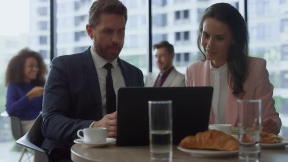 Motivated Business Group Discuss Project Success Using Laptop Computer in Cafe