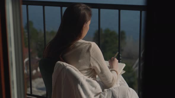 Girl Relaxing with Sketching at the Balcony