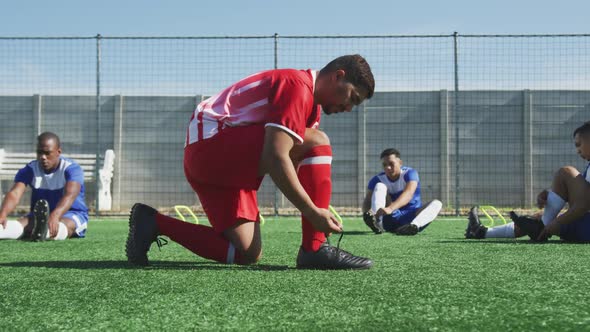 Soccer players tying his shoes on field