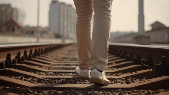 Tourist Legs Walking On Railway Middle Of Rail. Businessman Feet In Pants Walking On Rail Road.