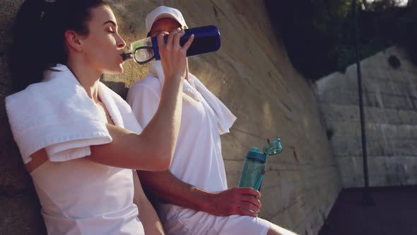 Woman and man playing tennis on a sunny day