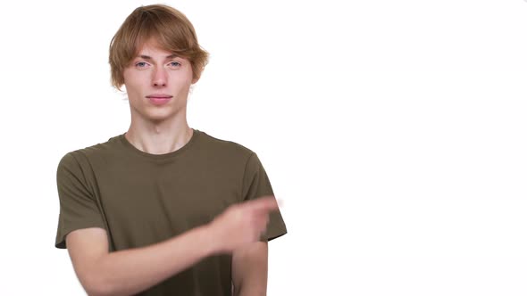 Portrait of Upset Guy in Tshirt Expressing Dislike with Gesturing Thumb Down at Something Copy Space