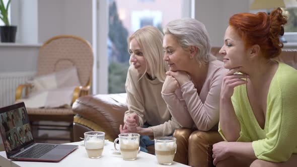 Three Women Sitting at Home Conferencing with Group of Friends in Video Chat Talking