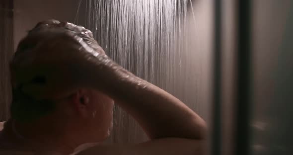 a Man Washes in the Shower Room Under Jets of Water