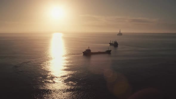 Cargo Ships Silhouette Sailing in Sunset Ocean alt