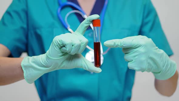 Medical Doctor Nurse Woman Wearing Protective Mask and Latex Gloves - Holding Blood Test Tube