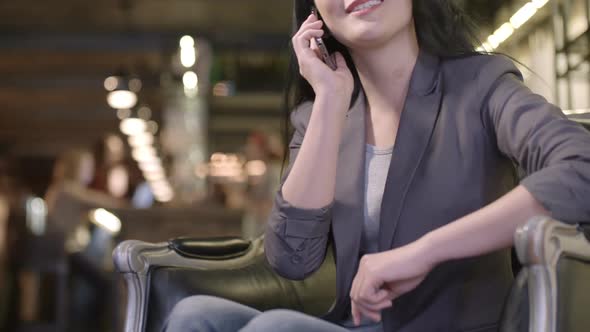 Asian Businesswoman Talking on Phone in Cafe
