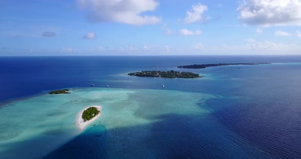 Tropical fly over clean view of a sandy white paradise beach and blue sea background 