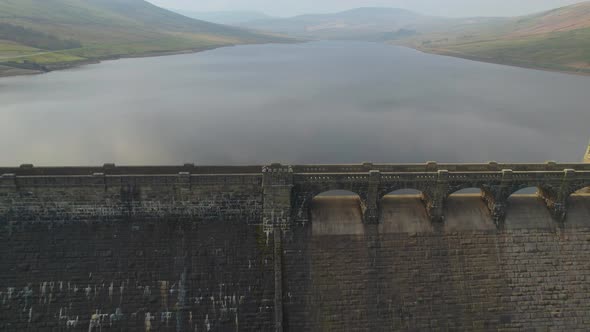 Pull out aerial over the dam at Scar House Reservoir Yorkshire, England.