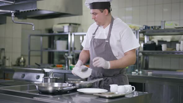 Portrait of Professional Chef in Cook Hat and Apron Adding Sugar in Cooking Pan Turning Pineapple