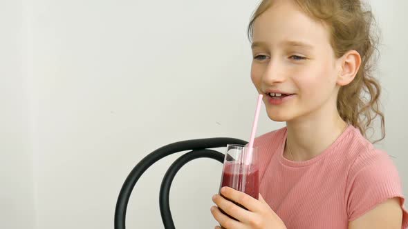 Sweet Little Girl Drinks Raspberry Smoothie and Smiles