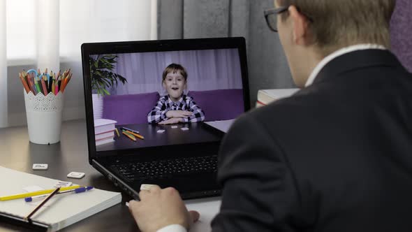 Man Teacher Making Video Call on Laptop with Little Pupil. Distance Education