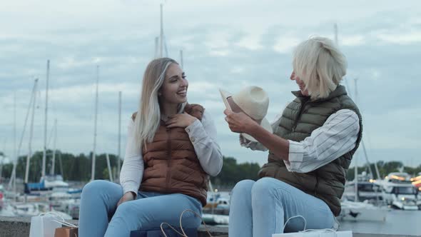 Two Women Sitting on Embankment after Shopping