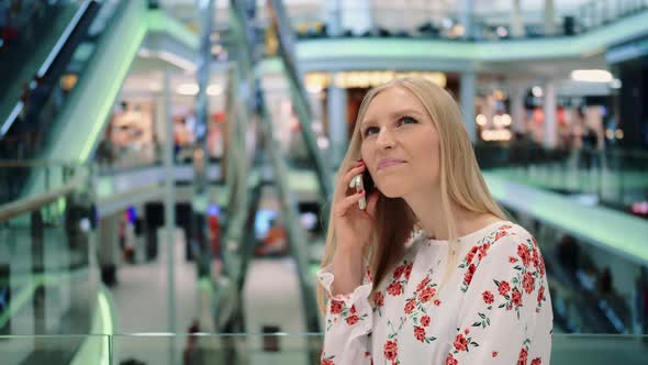 Young Woman Speaking on Phone in Mall