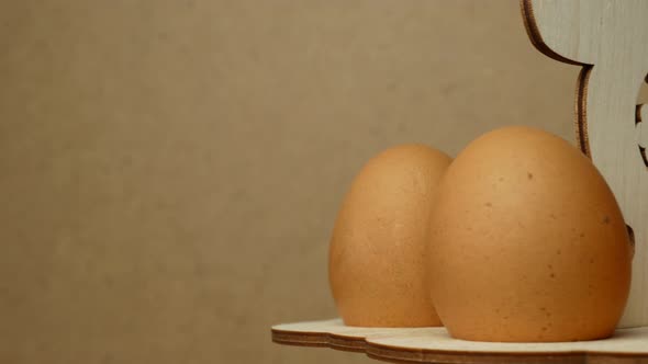 Rotation of eggs in an Easter stand made of wood on a gray background. Easter concept.close up