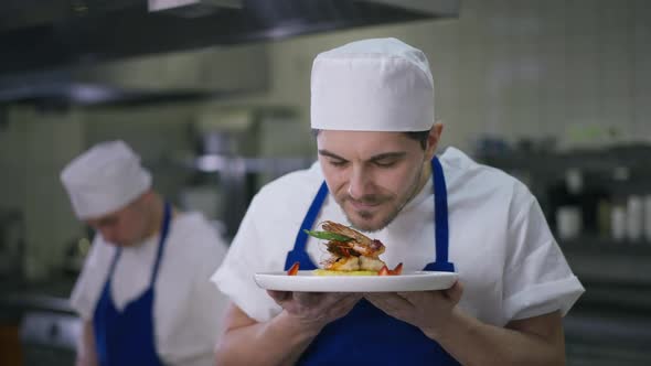 Happy Caucasian Male Cook Smelling Tasty Seafood Stretching Plate Looking at Camera Smiling