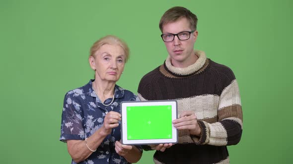 Happy Grandmother and Grandson Showing Digital Tablet Together