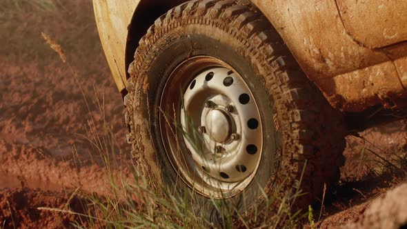 SUV Car is driving off-road with mud and puddles, closeup of wheels, down view. Concept of traveling