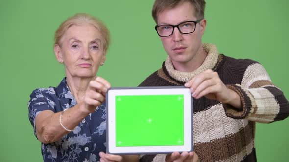 Happy Grandmother and Grandson Showing Digital Tablet Together