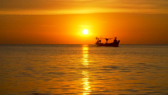 Fisher Boat at Sunset Floating on the Horizon