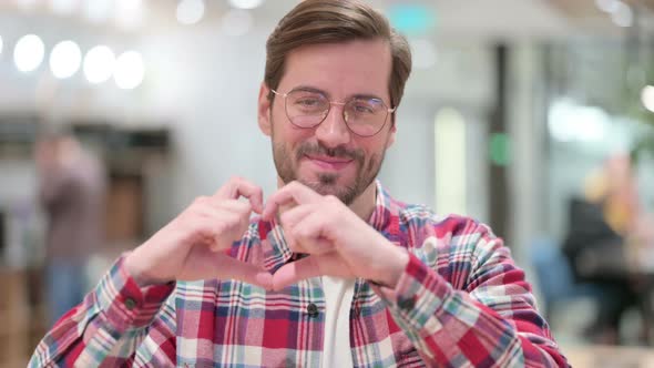 Portrait of Male Designer Showing Heart Shape By Hand