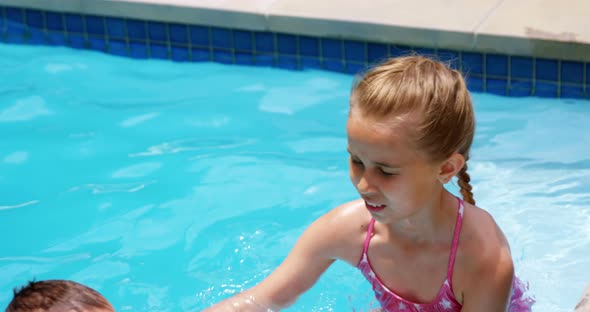 Sibling enjoying in swimming pool