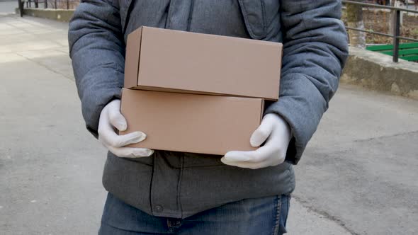 a man wearing white surgical gloves is holding a brown delivery