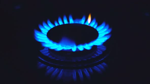 Stove Top Burner Igniting Into a Blue Cooking Flame.