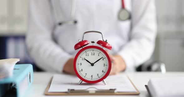 Red Alarm Clock Standing on Doctor Table in Clinic  Movie Slow Motion