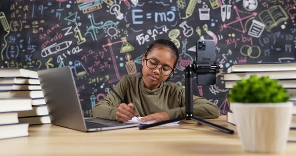 Girl kid studying online with headset in classroom