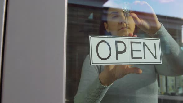 Woman Hanging Banner with Closed Word on Door