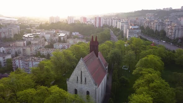 Round View Of Beautiful Church between trees forest And View of monument Town Cluj, Romania, Transyl