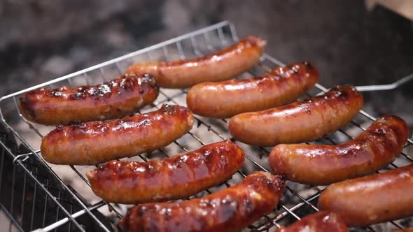 Closeup View of Tasty Sausages Grilling on Charcoal Grill Grate
