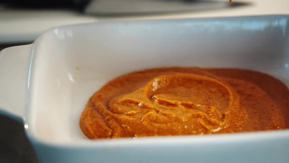 Professional restaurant kitchen, close-up: the sauce is applied to a baking sheet